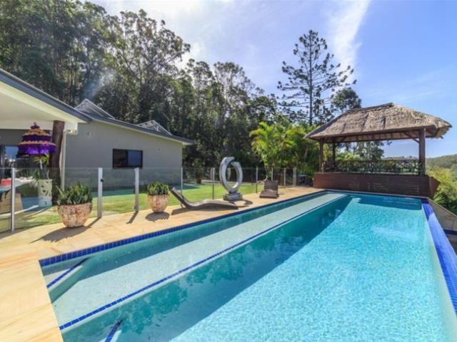 Swimming Pool With a Gazebo, Sun Deck, and House on a Hillside on a Sunny Day — Banora Pools in Tweed Heads South, NSW