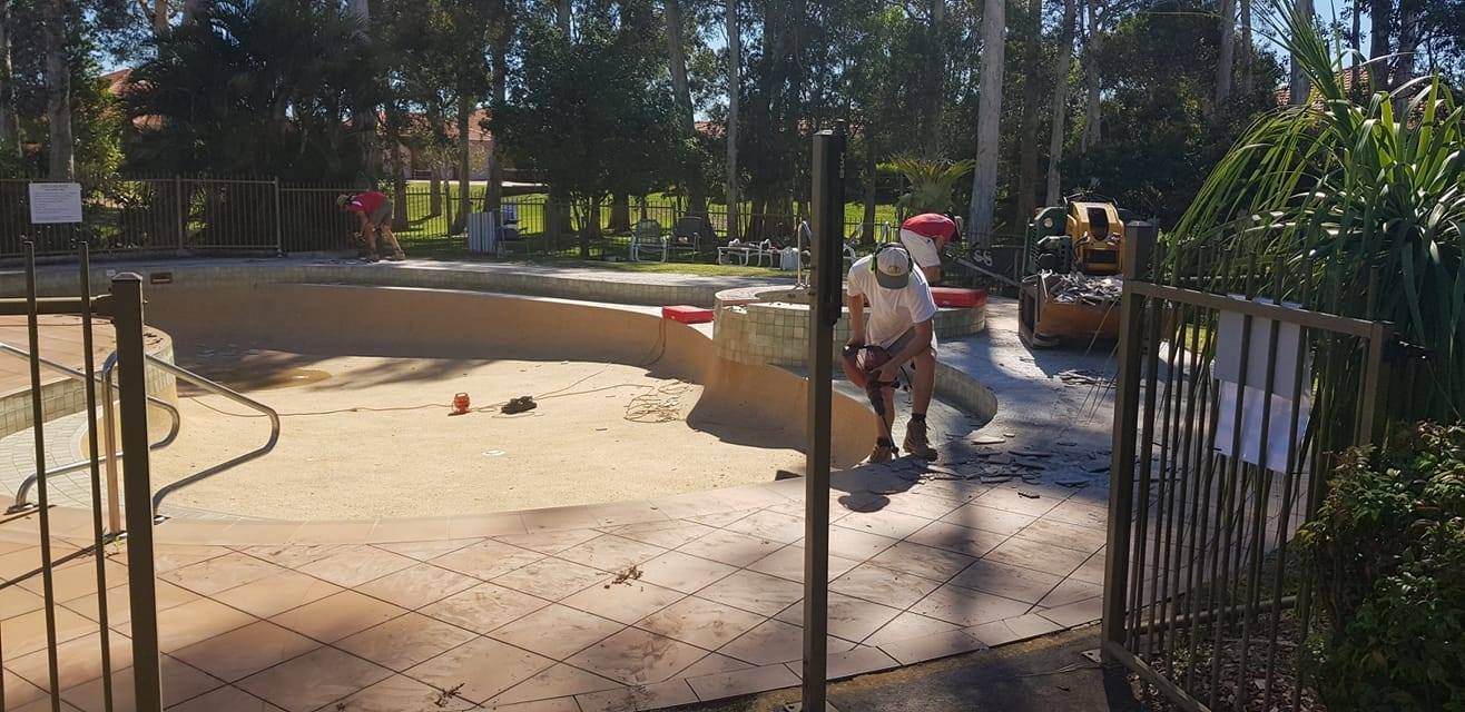 Workers Constructing a Pool With One Person Walking With Tools — Banora Pools in Ballina, NSW