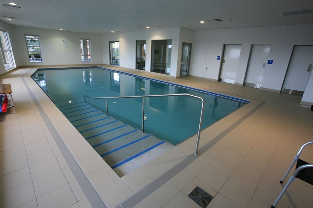 Indoor Pool With Steps, Handrails, and Doors Along the Wall — Banora Pools in Ballina, NSW