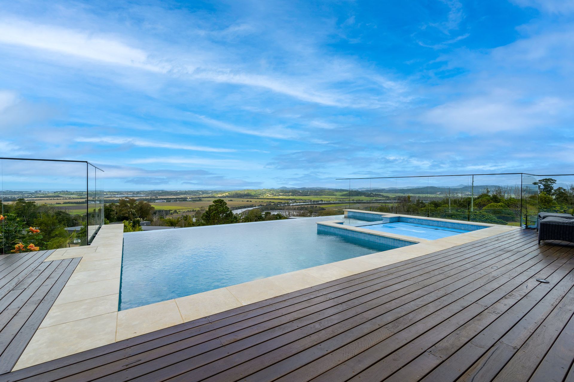 Infinity pool with a view of green fields and blue sky.