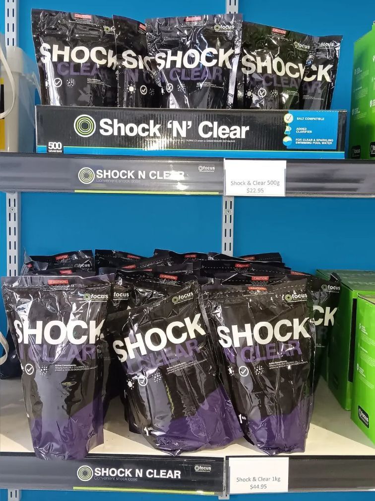 Shelf Display of Shock 'n' Clear Pool Shock Products, in Black and Purple Bags — Banora Pools in Currumbin, NSW