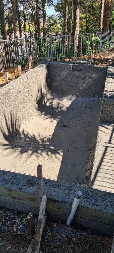 An Unfinished Swimming Pool Pit Under Construction. Wood and Pipes at the Edge — Banora Pools in Murwillumbah, NSW