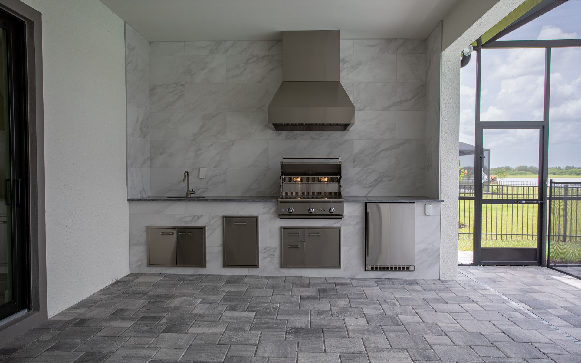Elegant Outdoor Kitchen Delta Heat Fridge Tradewind Hood Grill Tile Backsplash Valencia Trails , Naples FL