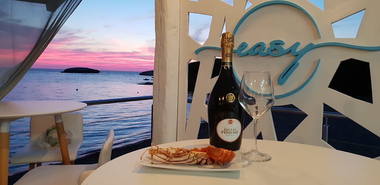Cena sul mare con pesce e vino bianco