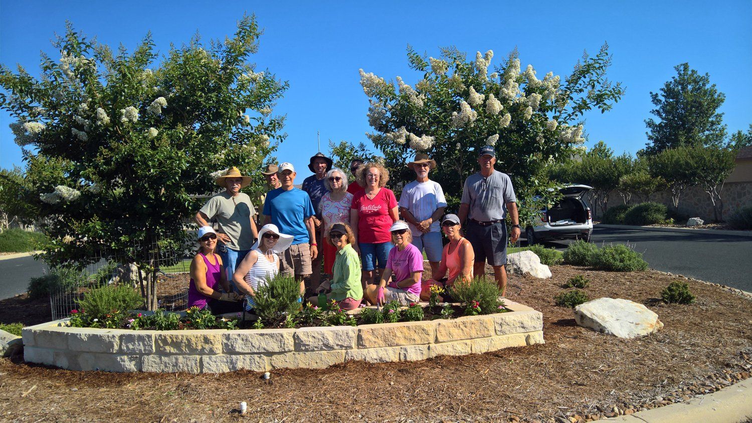 A group of people are posing for a picture in front of a tree.