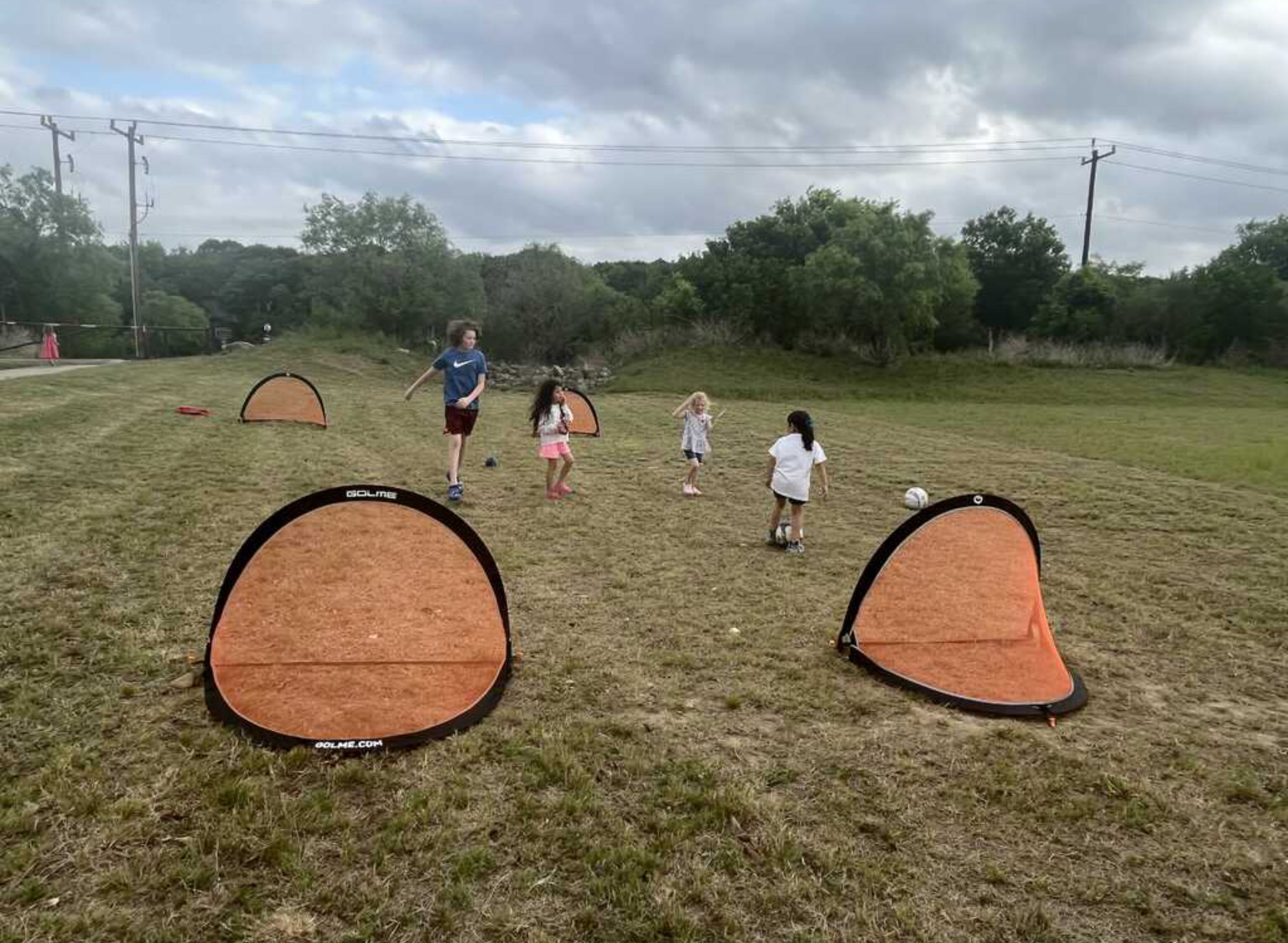 A group of children are playing soccer in a field.