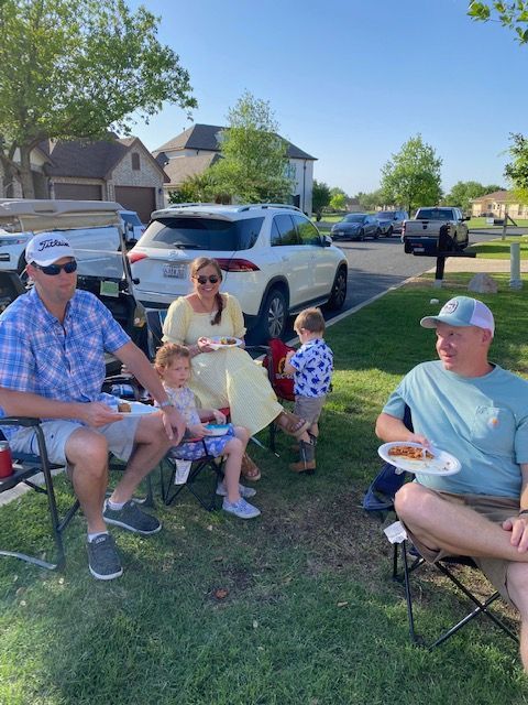 A group of people are sitting on the grass eating food