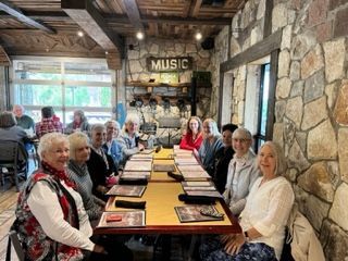 A group of people are sitting at a long table in a restaurant.