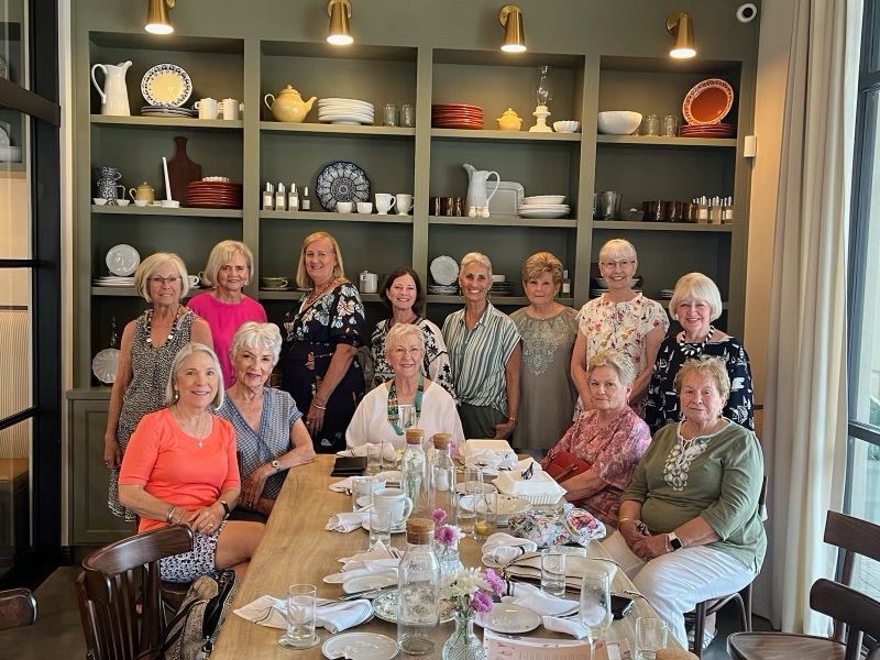 A group of older women are sitting around a table.