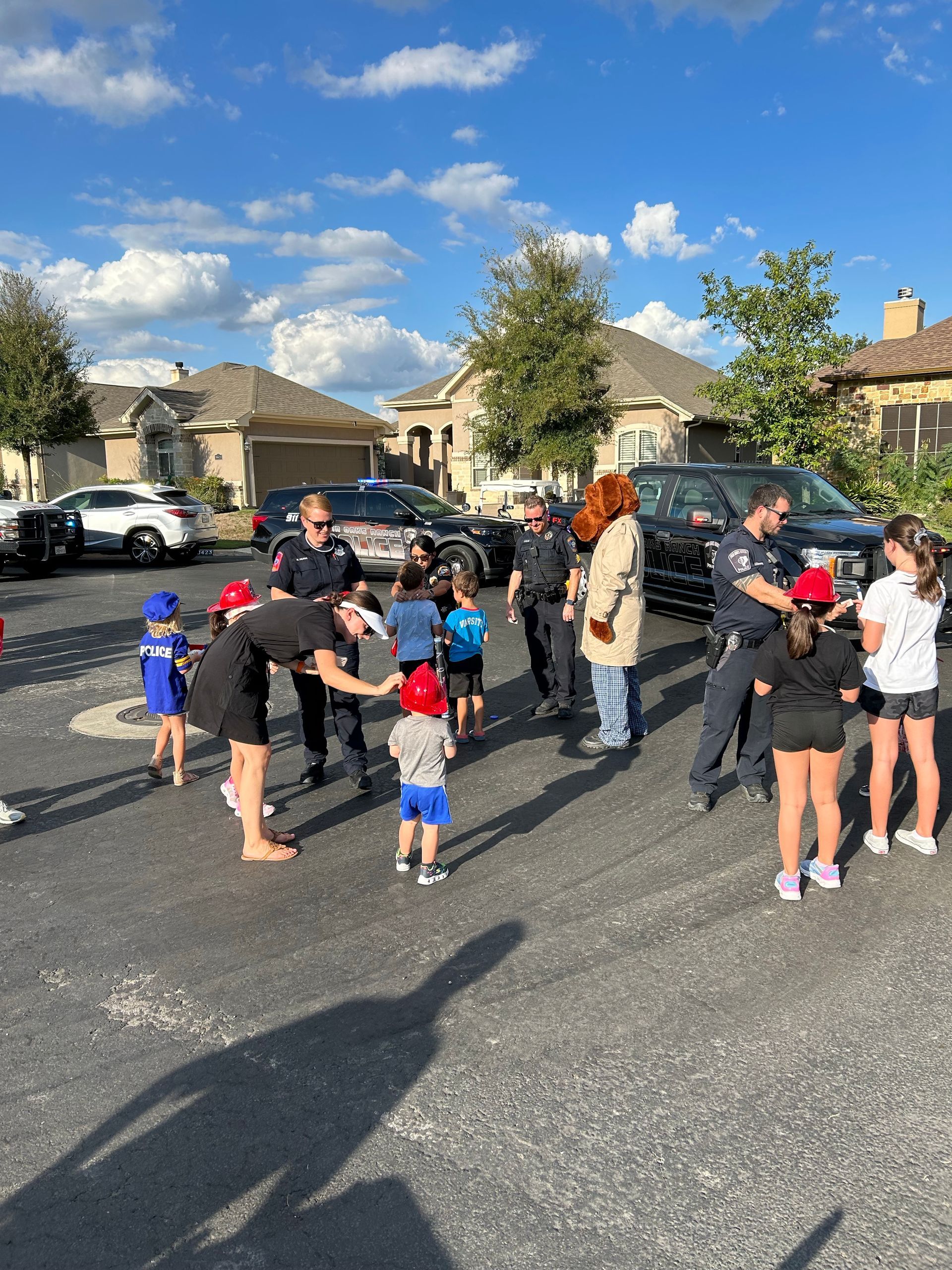 A group of people are standing in a parking lot with police officers.