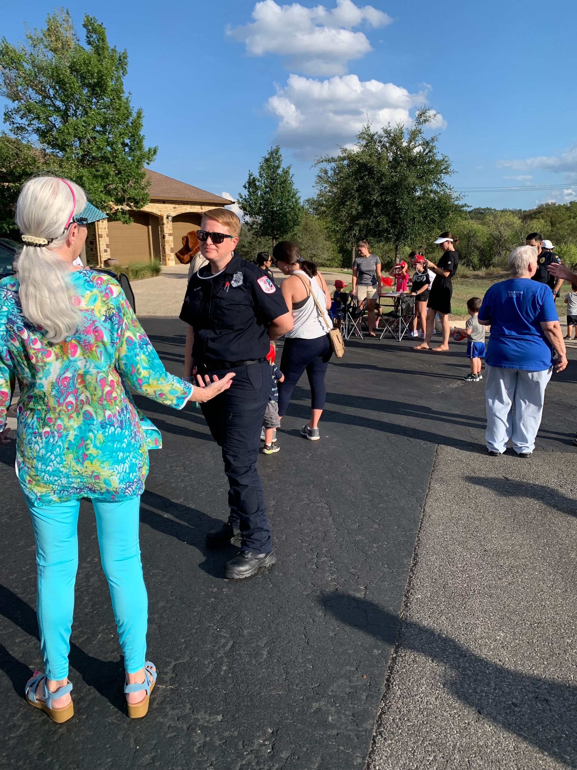 A police officer is standing next to a woman in a blue shirt