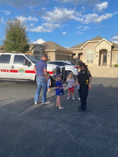 A group of children are standing in front of a police van.
