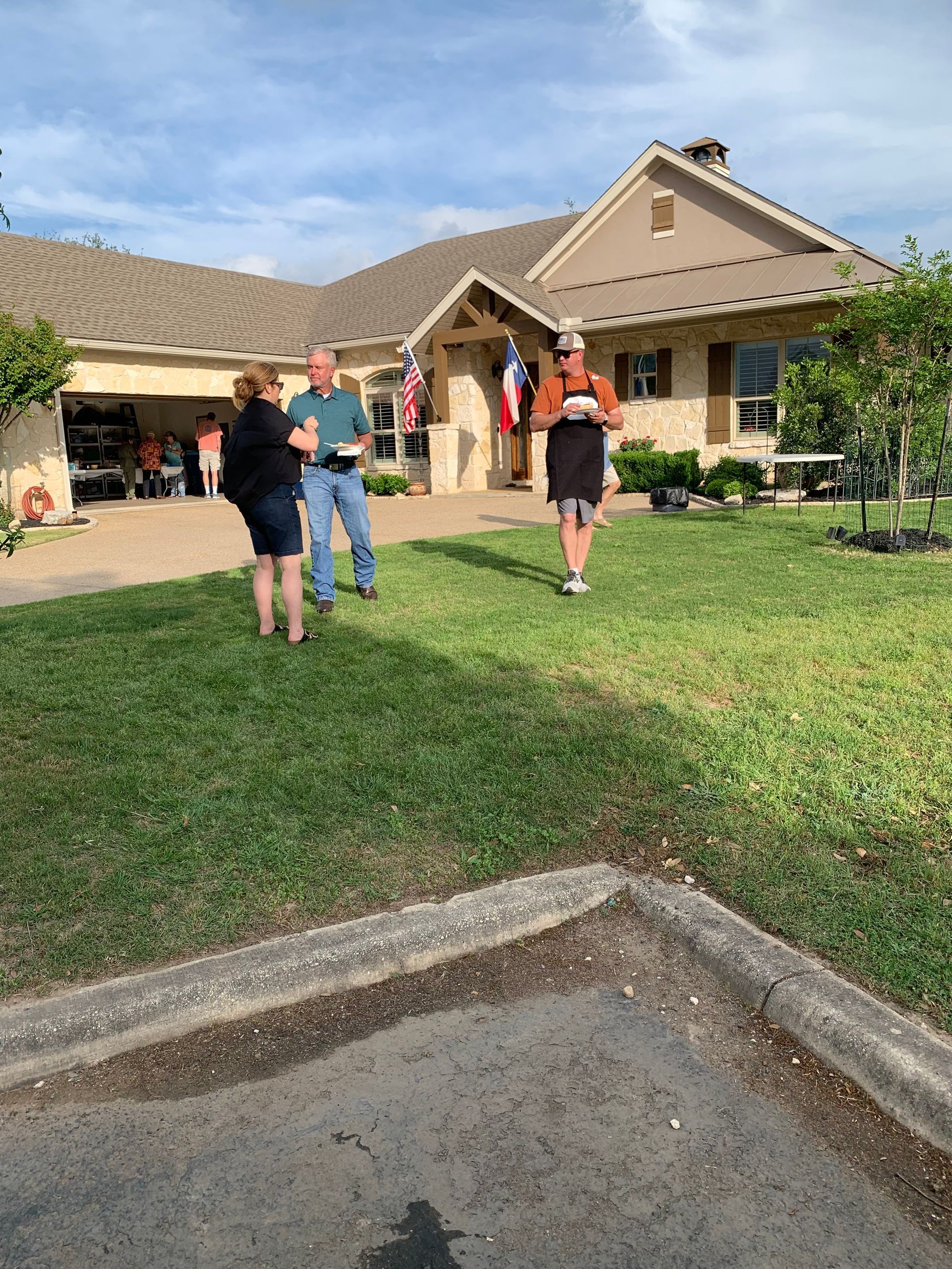 A group of people are standing in front of a house.