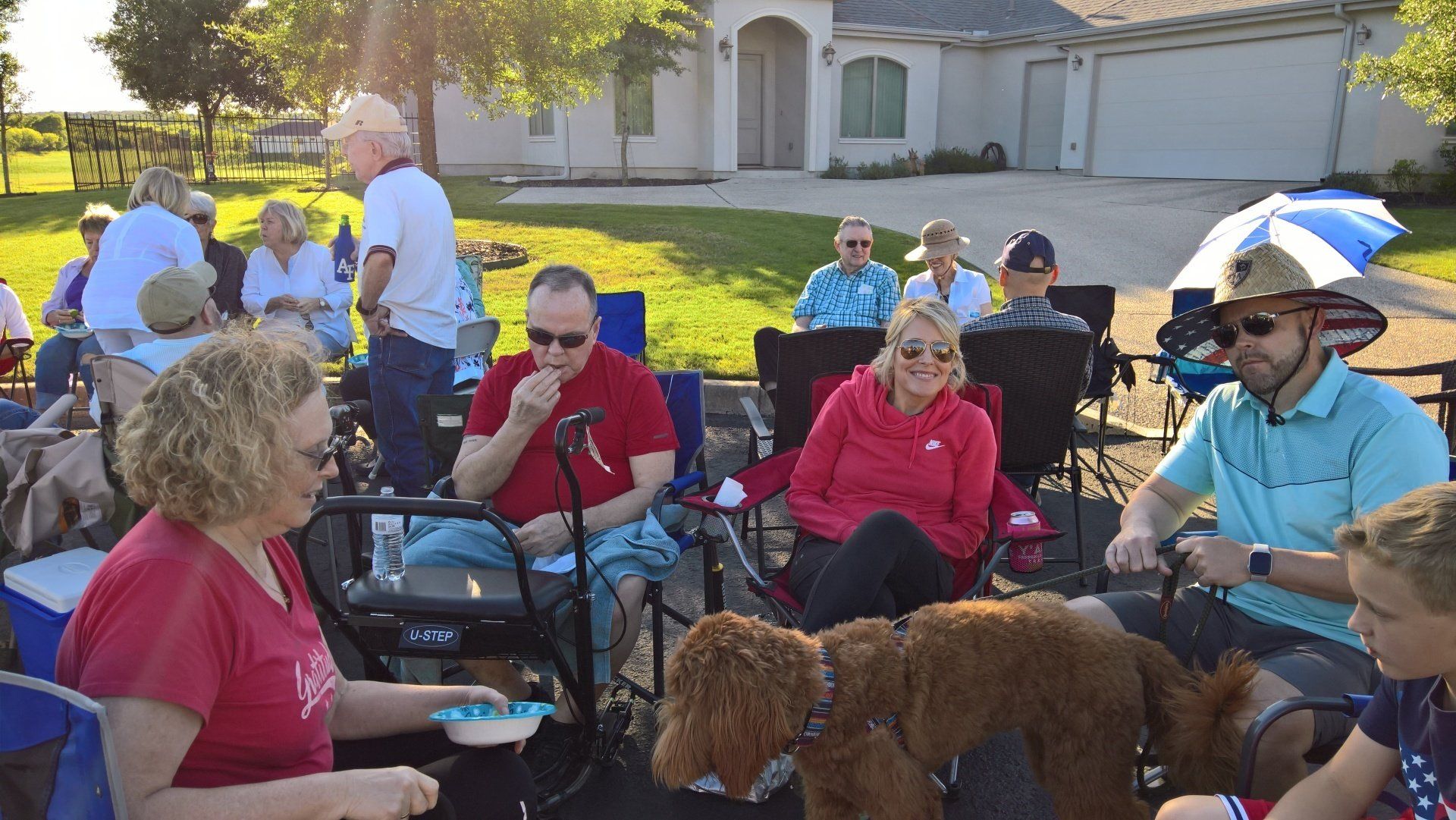 A group of people are sitting around a fire pit with a dog.
