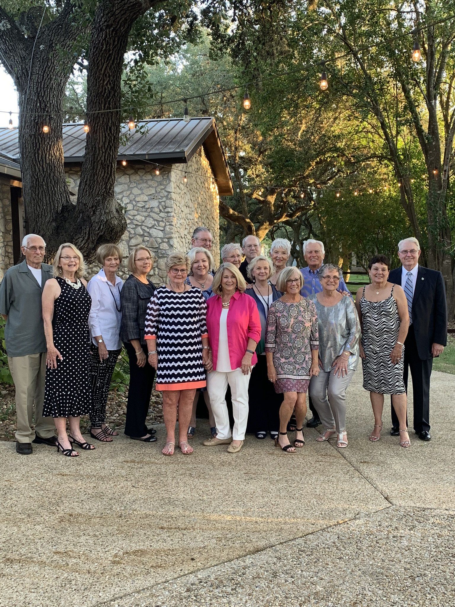 A group of people are posing for a picture in front of a stone building.