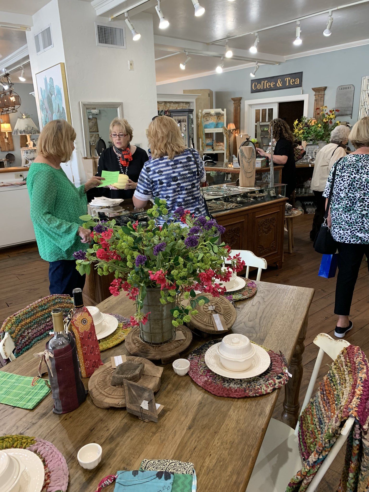 A group of women are standing around a table in a store.