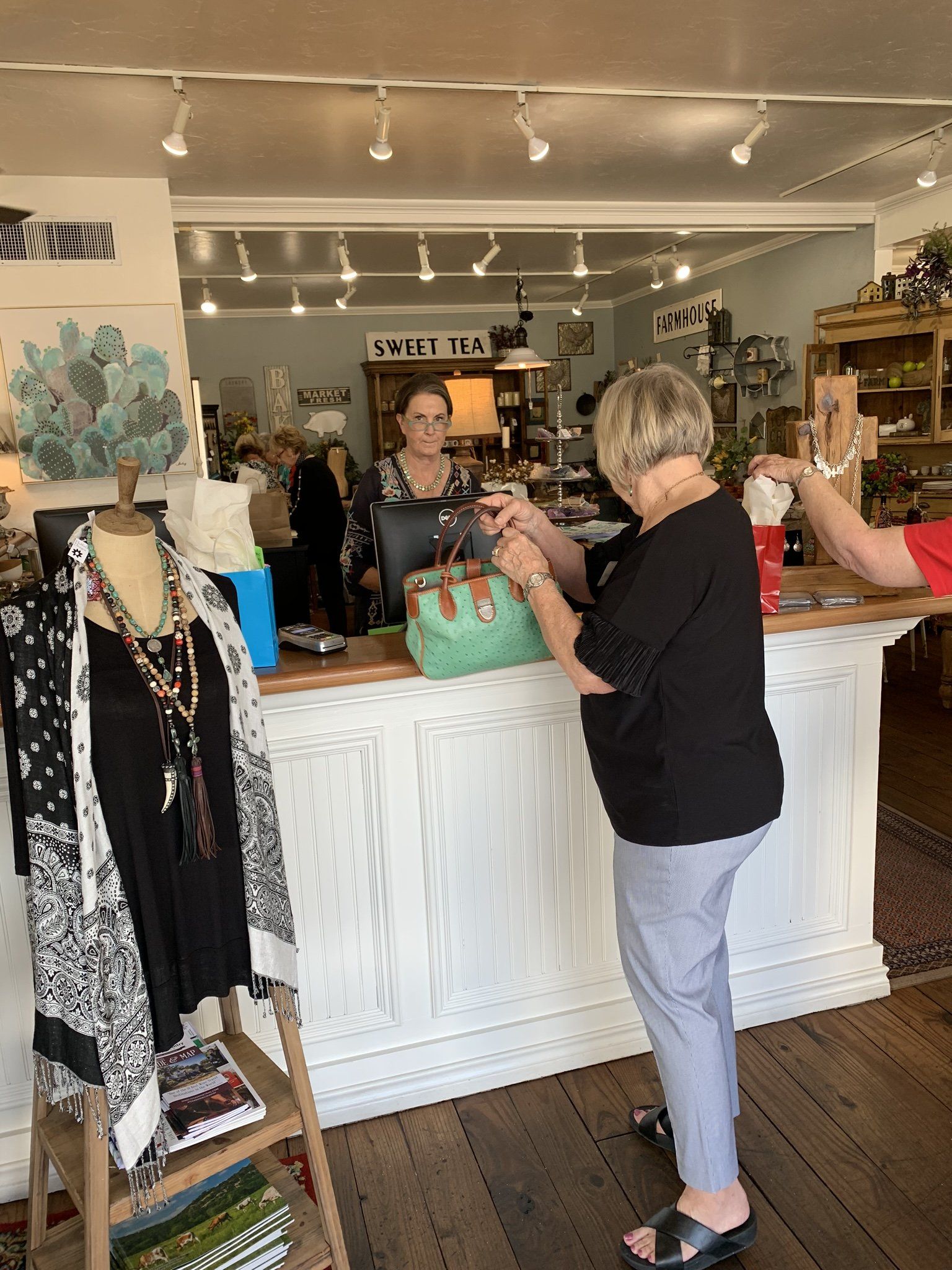 A woman is standing at a counter in a store.