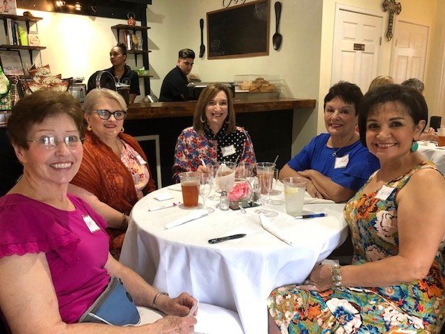 A group of women are sitting at a table with drinks.