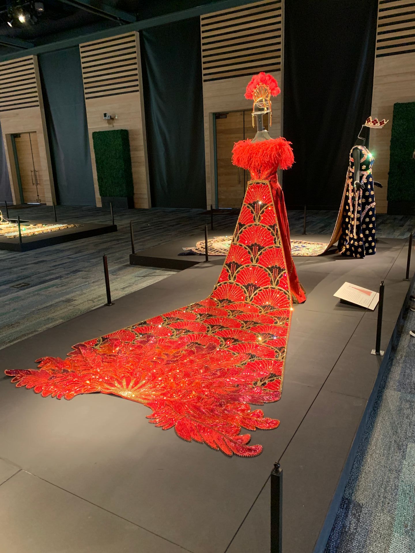 A long red dress is on display in a museum.