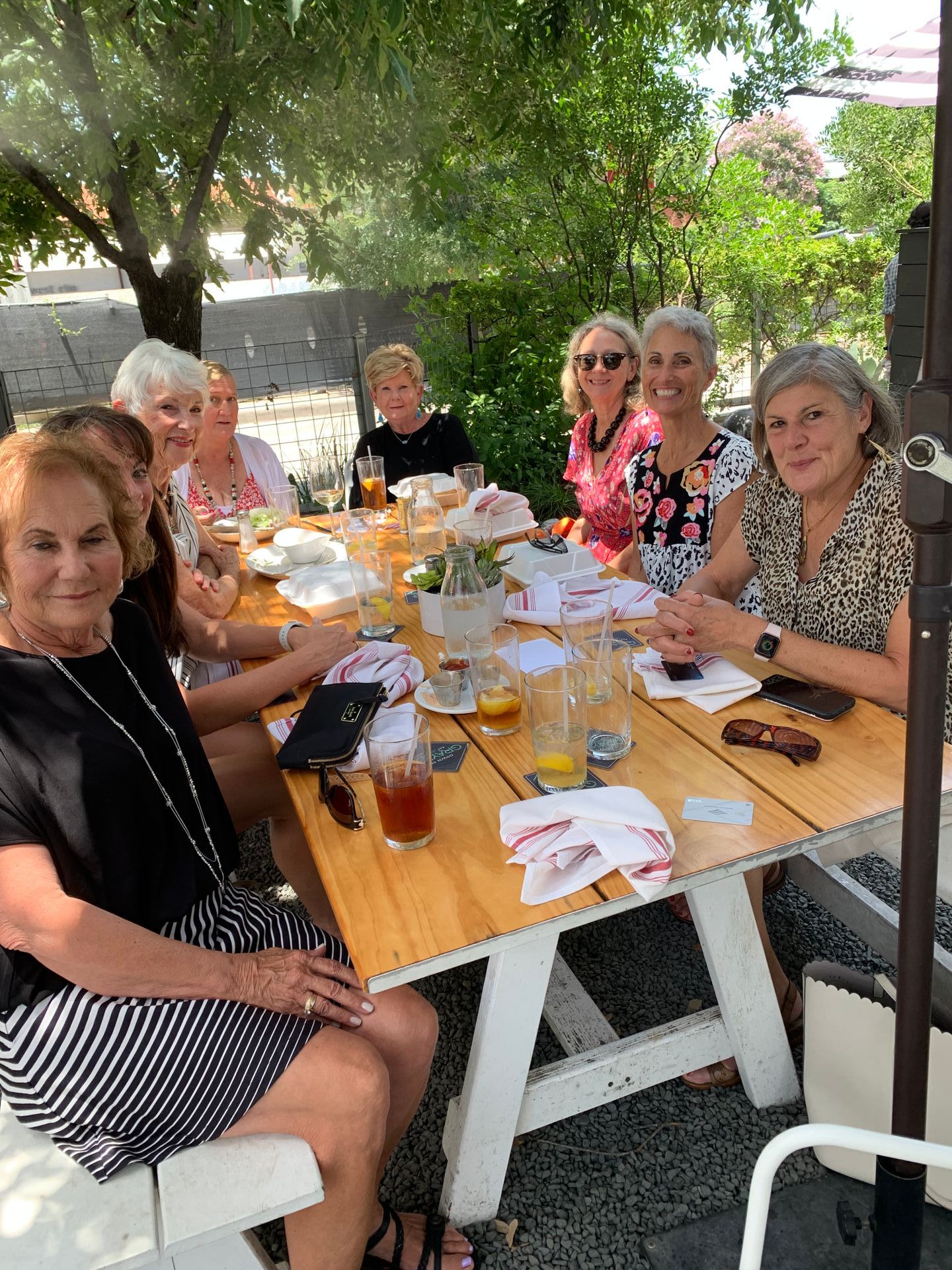 A group of women are sitting around a table eating food.