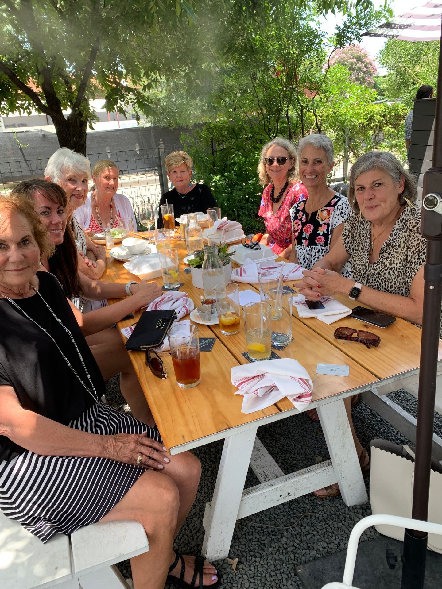 A group of women are sitting around a table eating food.