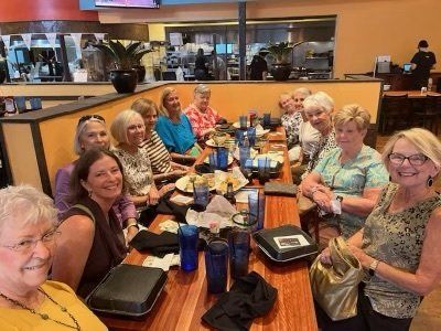 A group of women are sitting at a long table in a restaurant.
