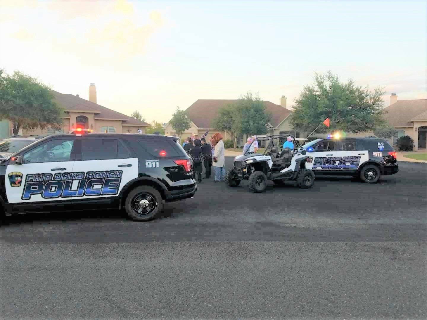 A group of police cars are parked on the side of the road.