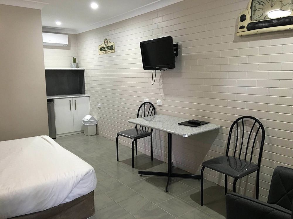 A Hotel Room With A Bed, Table, Chairs And Television — Country Leisure Dubbo in Dubbo, NSW