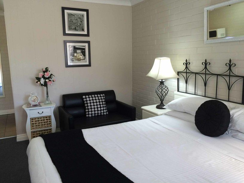 A Bedroom With A Bed A Chair And A Lamp — Country Leisure Dubbo in Dubbo, NSW