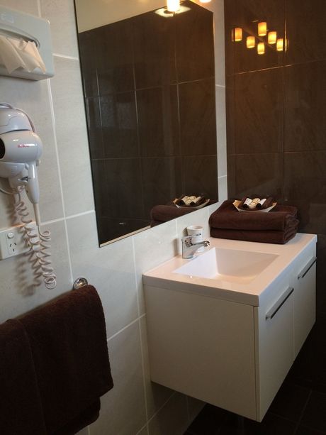 A Bathroom With A Sink A Mirror And A Hair Dryer — Country Leisure Dubbo in Dubbo, NSW