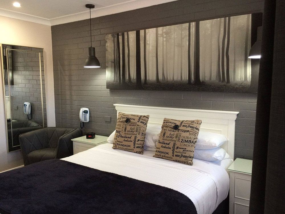 A Hotel Room With A Large Painting On The Wall Above The Bed — Country Leisure Dubbo in Dubbo, NSW