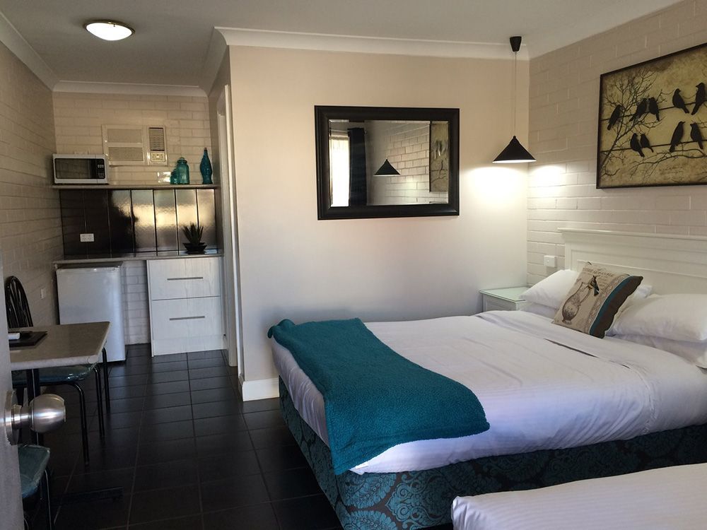 A Hotel Room With Two Beds, A Table And A Mirror — Country Leisure Dubbo in Dubbo, NSW