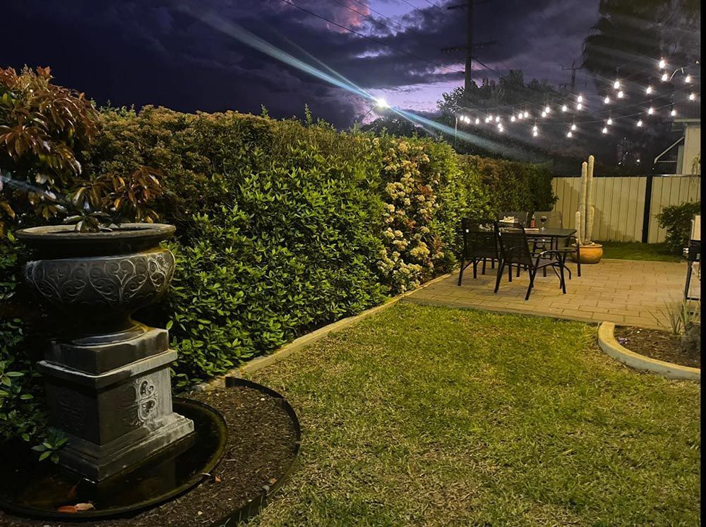 A Garden With A Fountain And Tables And Chairs At Night — Country Leisure Dubbo in Dubbo, NSW
