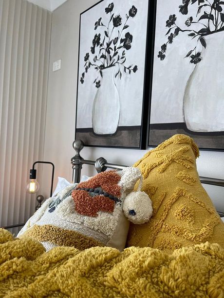 A Bed With A Yellow Blanket And Pillows In A Bedroom — Country Leisure Dubbo in Dubbo, NSW