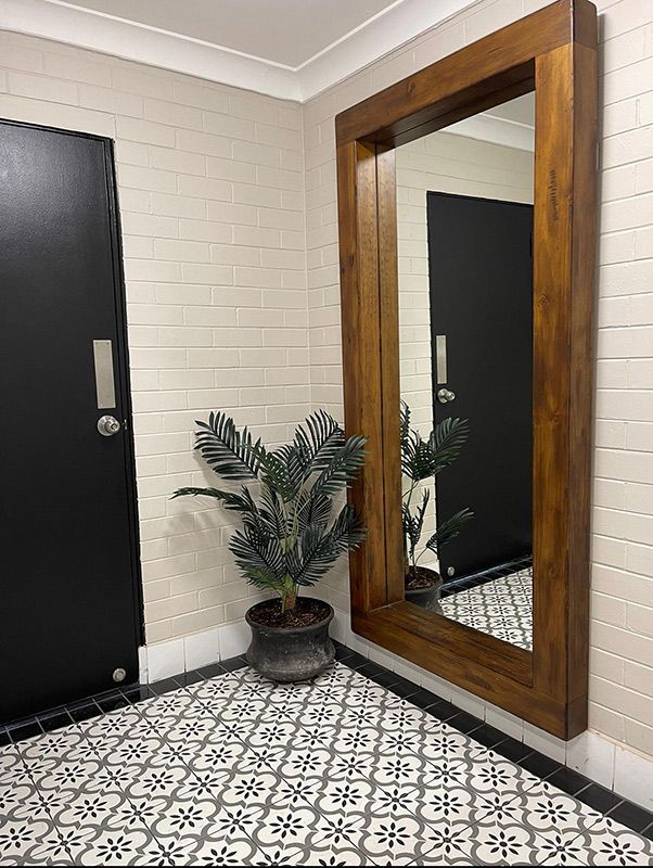 A Large Mirror Is Hanging On A Wall In A Hallway Next To A Potted Plant — Country Leisure Dubbo in Dubbo, NSW
