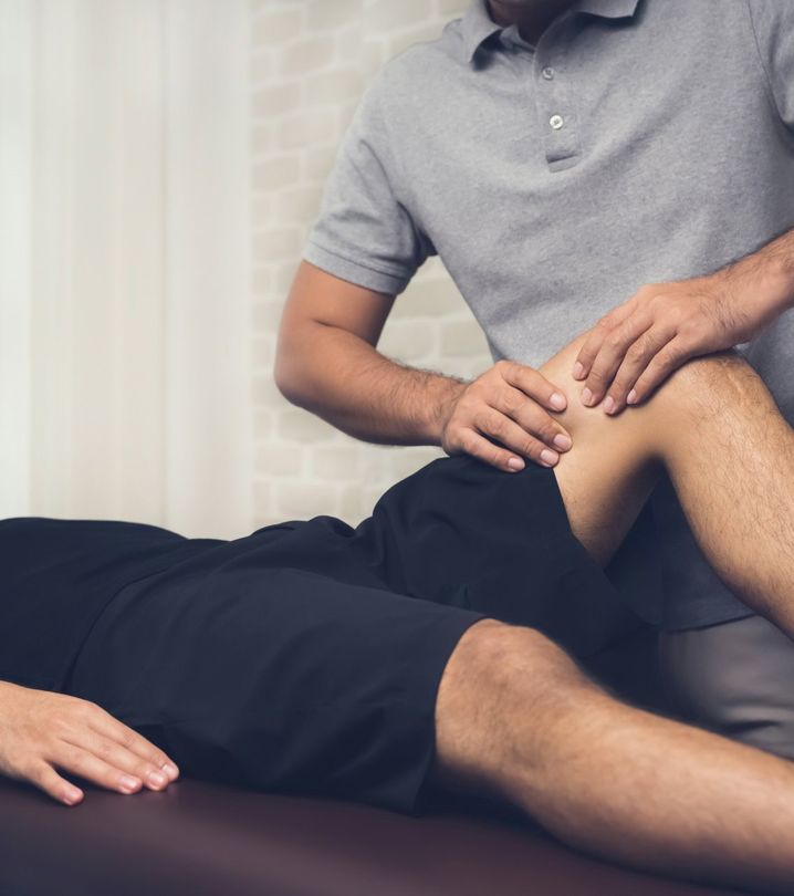 Therapist Treating Injured Leg Of Athlete Male Patient In Clinic — 360 Muscle Therapy in Bolwarra Heights, NSW