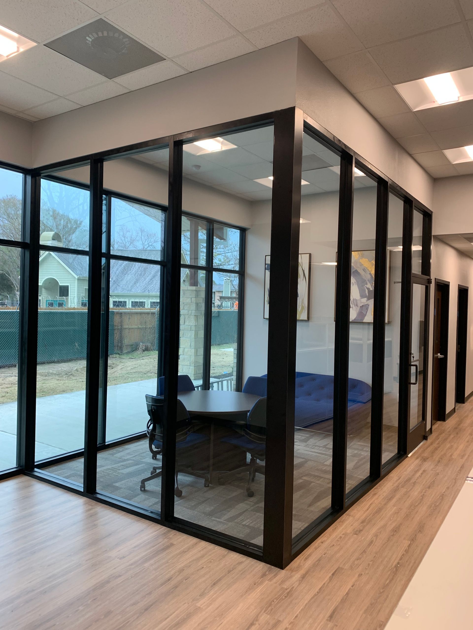 A room with a lot of windows and a table and chairs in it.