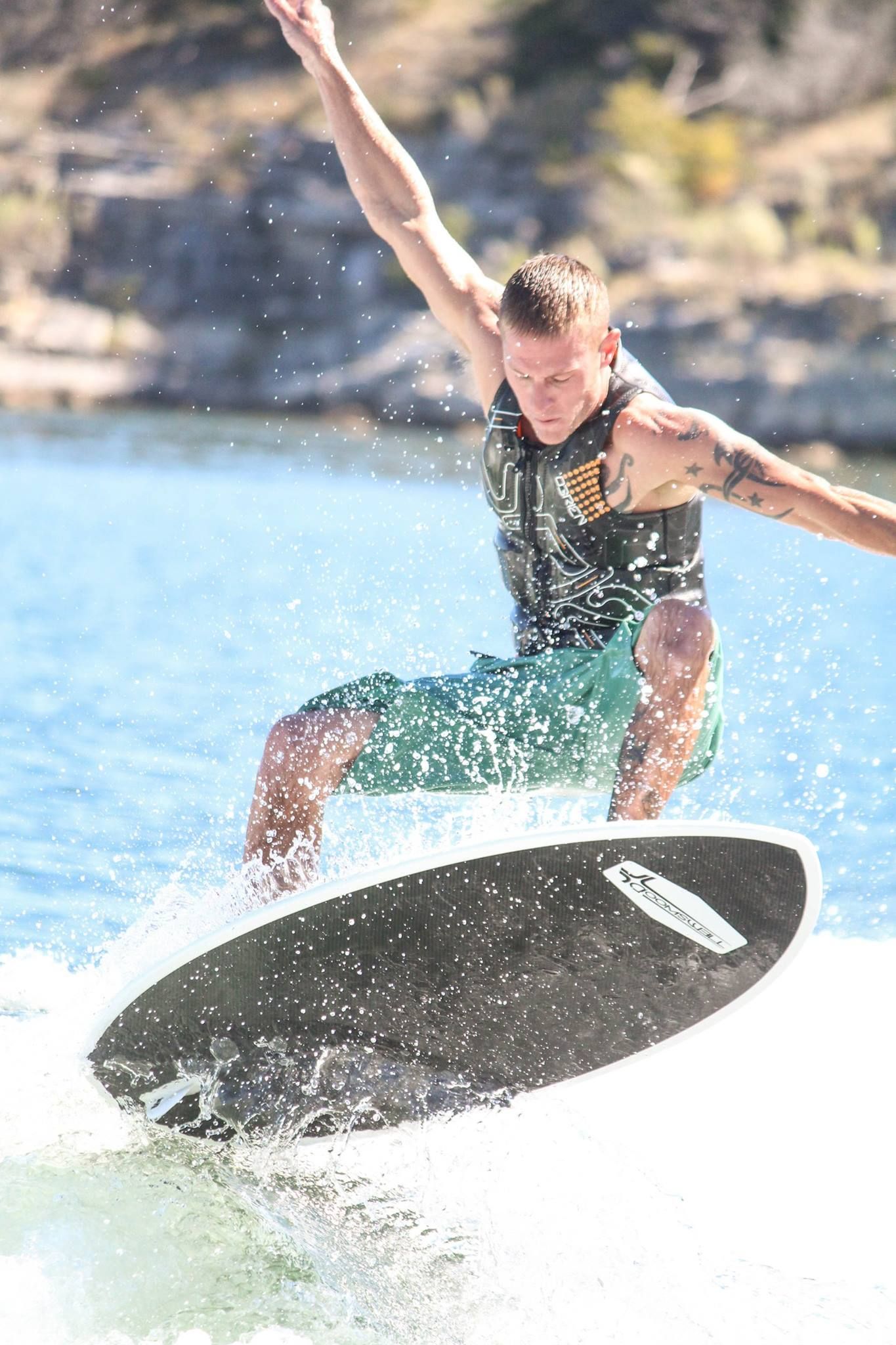 A man is riding a wave on a wakeboard in the water.