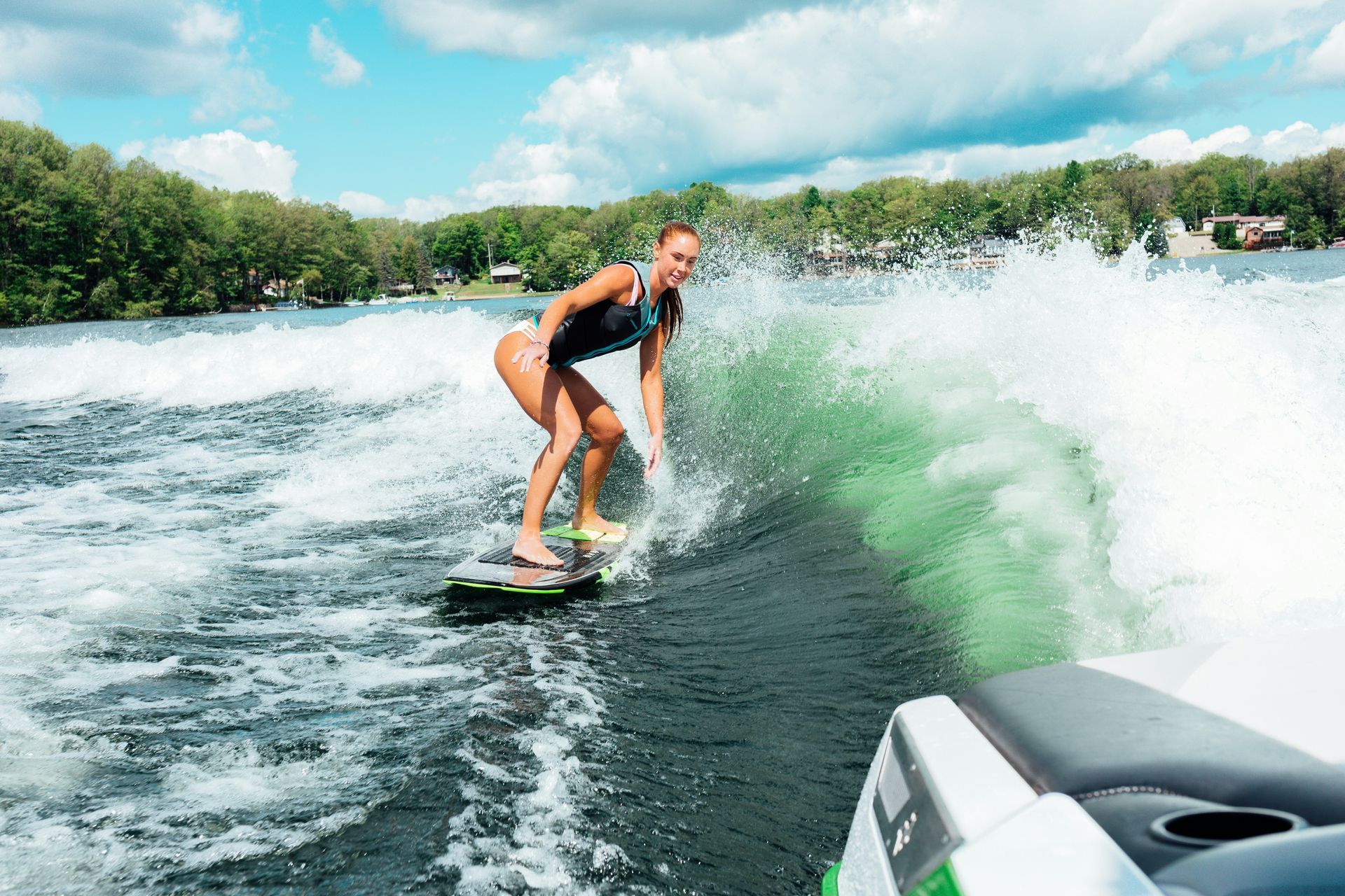 A woman is riding a wave on a wakeboard in the water.