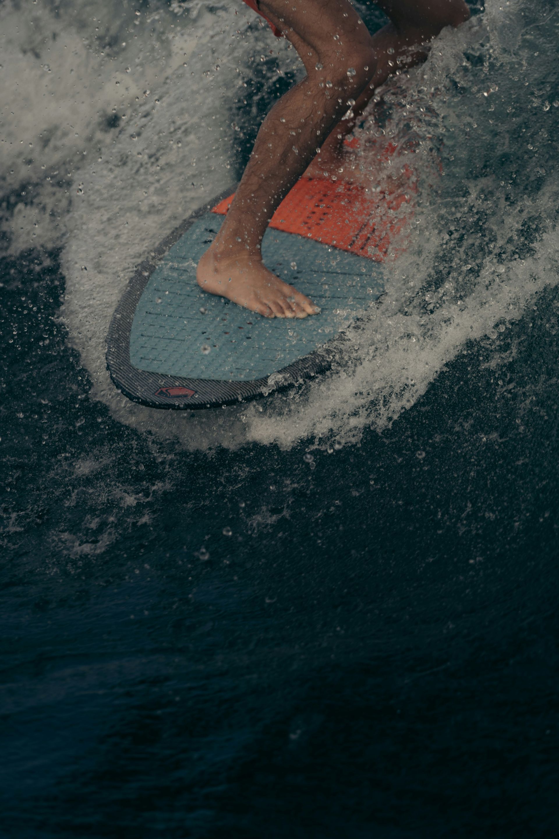 A person is riding a wave on a wakeboard in the ocean.