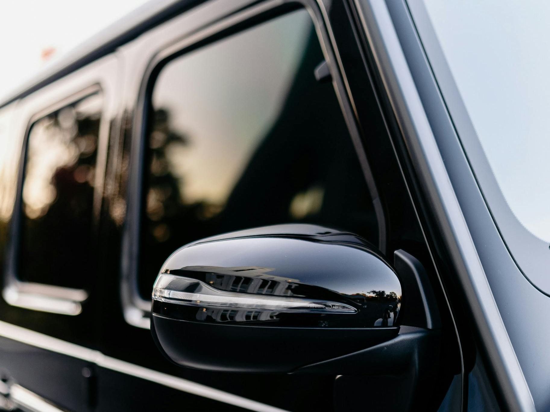 A close up of a black car 's side mirror