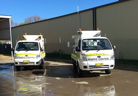 Two Traffic Control Trucks Are Parked In Front Of A Building - NSW - Midwest Traffic Management