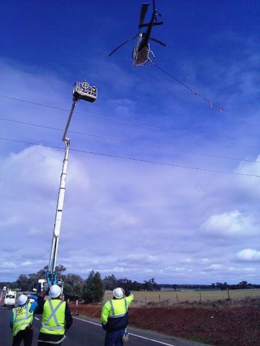 A Helicopter Is Flying Over A Road While People Watch - NSW - Midwest Traffic Management
