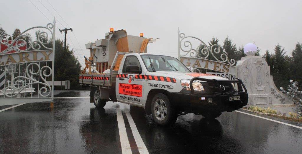 A White Truck Is Driving Down A Wet Road - NSW - Midwest Traffic Management
