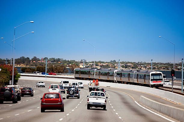 A Train Is Going Down The Highway Next To A Lot Of Cars - NSW - Midwest Traffic Management