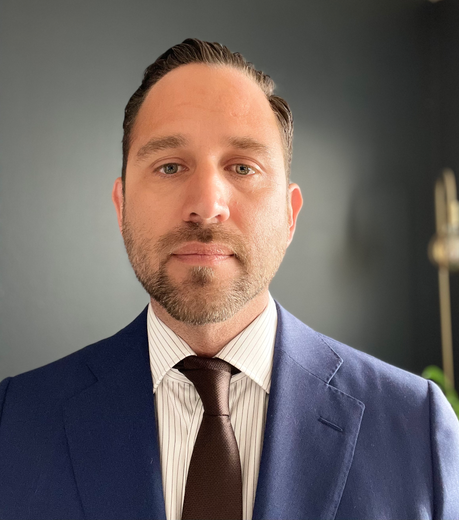 A man in a suit and tie is smiling for the camera.