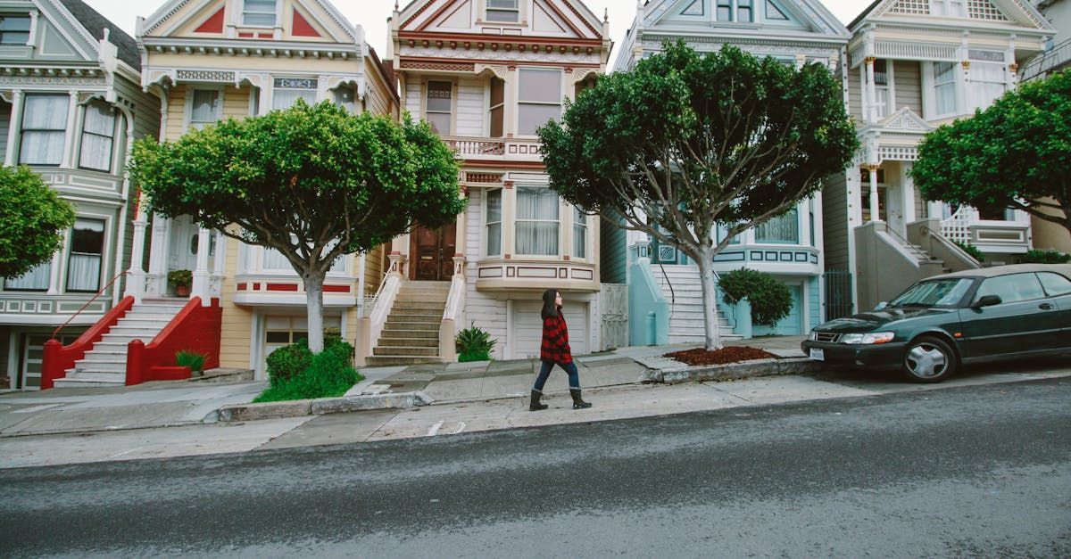 A woman is walking down a street in front of a row of houses