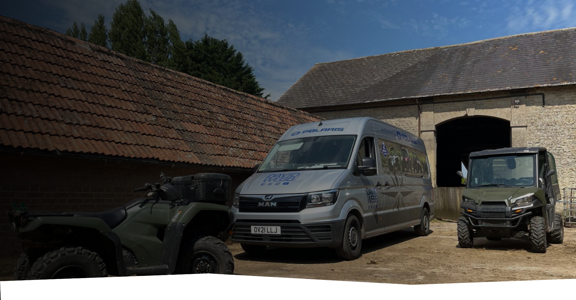 A van and an atv are parked in front of a building.