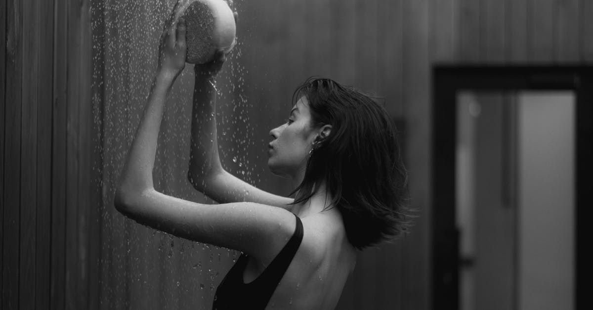 A woman is taking a shower in a black and white photo.
