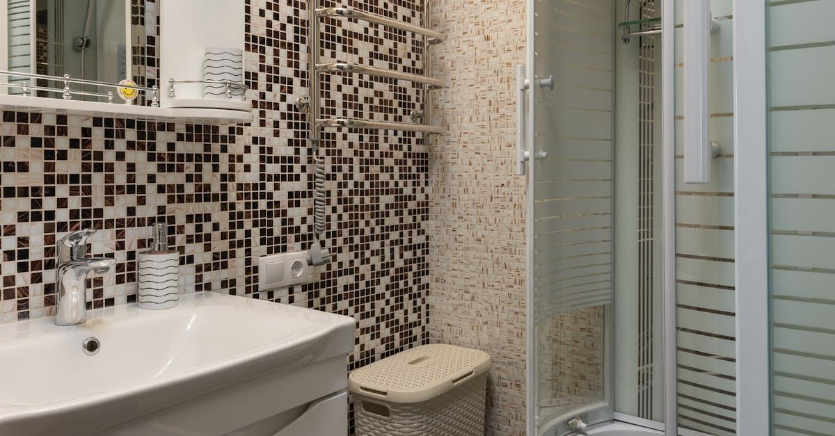 A bathroom with a sink , toilet , shower and mirror.